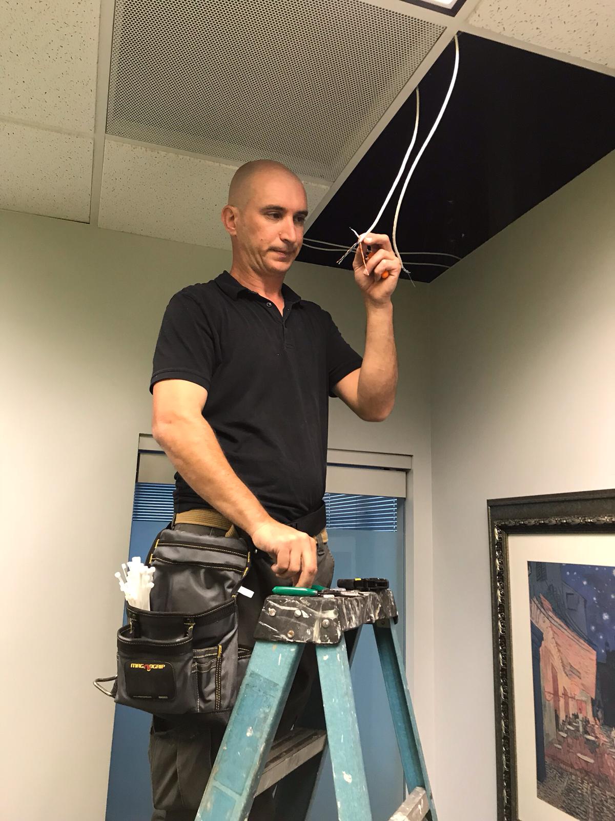 SLK Services technician performing HVAC ceiling work